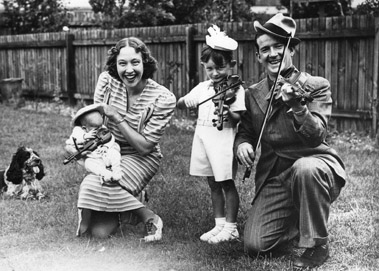 Former showgirl mum Sybil (aka Dorothy) holds Andrew. Brother Robin, and dad Ted Ray are on the violins.
